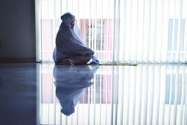 Oude vrouw doet aanbidding met behulp van biddende sluier