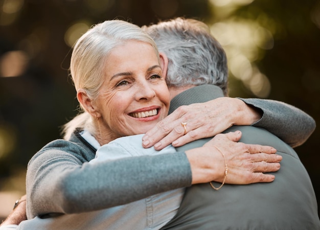 Oude vrouw gezicht en senior gelukkige paar knuffel zorg en geniet van quality time samen band en verbinding maken in natuurpark Ondersteuning van liefde en buiten man pensioen vrouw of huwelijk mensen omhelzen op date