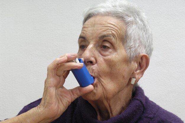 Oude vrouw met een inhalator