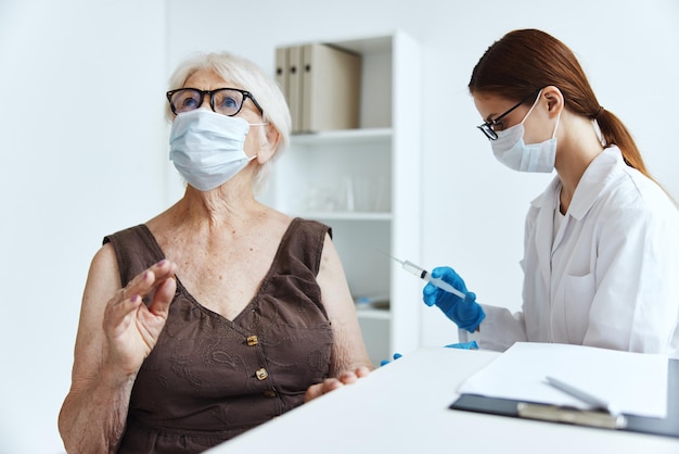 Oude vrouw met medisch masker in het ziekenhuis voor vaccinaties covid paspoort