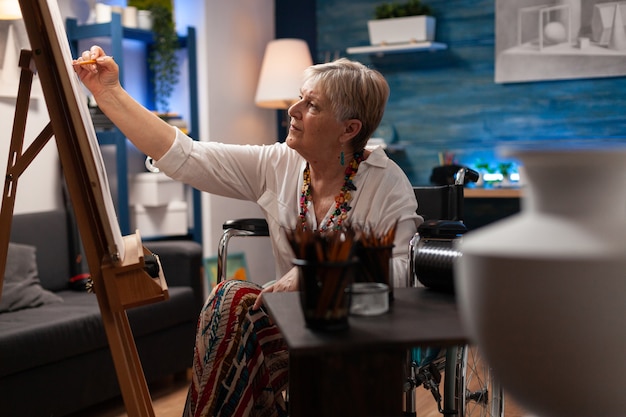 Oude vrouw tekenen op canvas met potlood