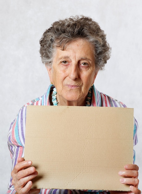 Foto oude vrouw tussen de 70 en 80 jaar oud met een stuk papier. vrije ruimte voor een tekst