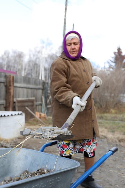 Oude vrouw wast afwas russische oma maakt de tuin schoon