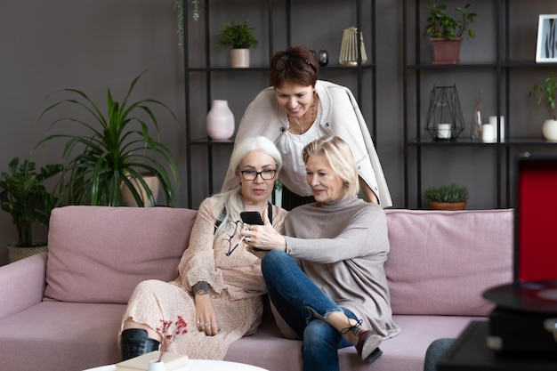 Oude vrouwen die thuis telefoon gebruiken