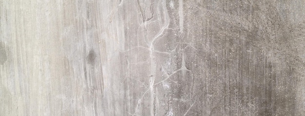 Oude vuile betonnen muur als achtergrond Grijze cementpleister Muurtextuur voor achtergrond Borstelkrassen op de muur