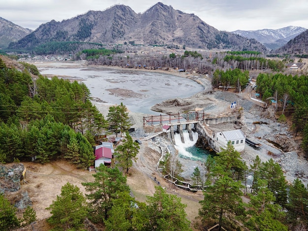 Oude waterkrachtcentrale op de rivier de chemal in altai op een zomerdag luchtfoto van bovenaf door d