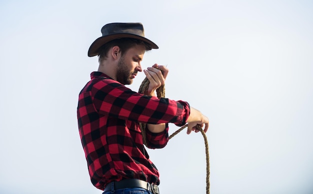 Oude westen man geruit hemd op ranch wilde westen rodeo Nadenkende man in hoed cowboy met lasso touw Western Vintage stijl man Wild West retro cowboy western cowboy portret