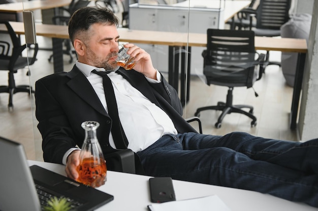 Oude zakenman die drinkt van stress