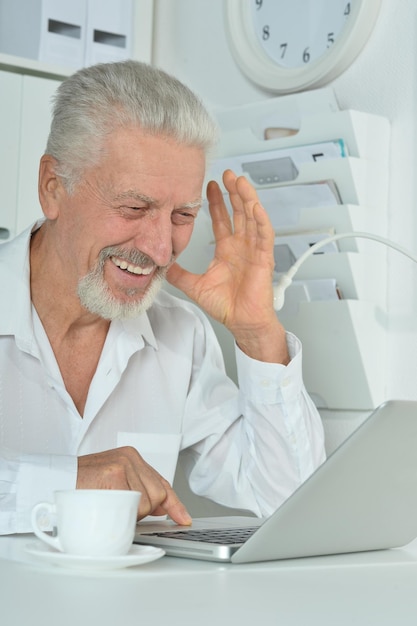 Oude zakenman met laptop aan het werk