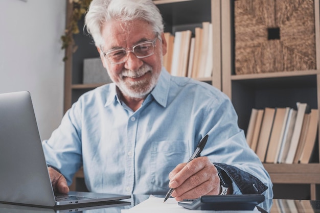 Oude zakenman of accountant hand met pen schrijven van notities en online werk doen