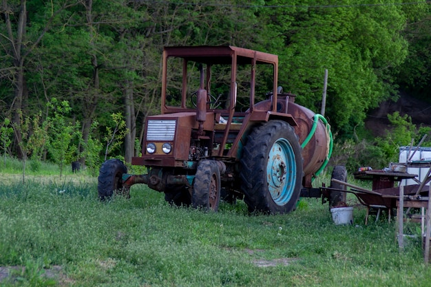 Oude zelfgemaakte roestige tractor met een vat.