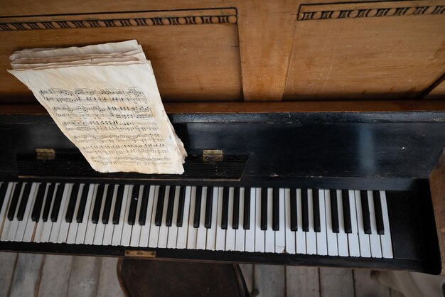 Foto oude zwarte piano in scheuren met noten