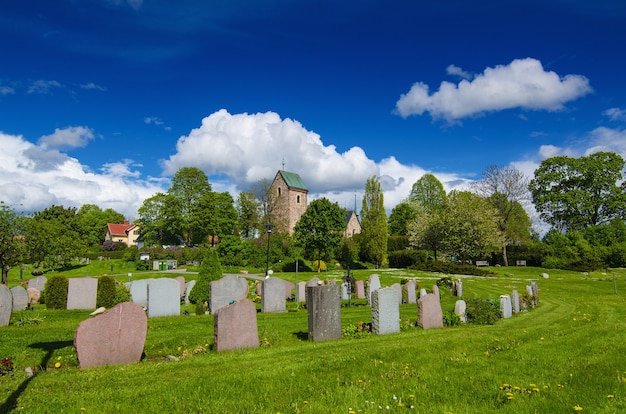 Oude Zweedse kerk met begraafplaats in klein stadje in de buurt van Stockholm - Vallentuna, spring levendige natuurlijke buiten Zweden achtergrond