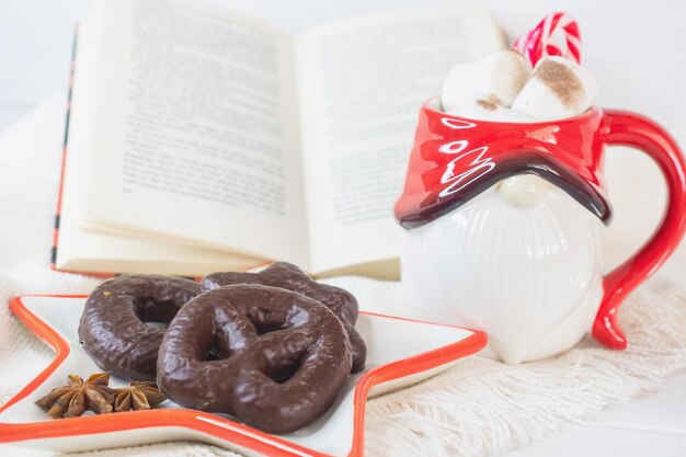 Oudejaarsavond achtergrond Kerstman mok met marshmallows kerstkoekjes open boek