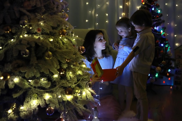 Oudejaarsavond het huis is versierd voor de vakantie netjes geklede kerstboom met een slinger en een gezin met cadeaus en een verrassing