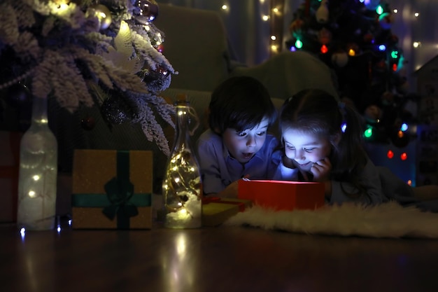 Oudejaarsavond Het huis is versierd voor de vakantie Netjes geklede kerstboom met een slinger en een gezin met cadeaus en een verrassing