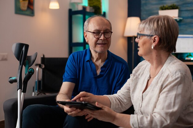 Ouder echtpaar met behulp van moderne tablet met online internet