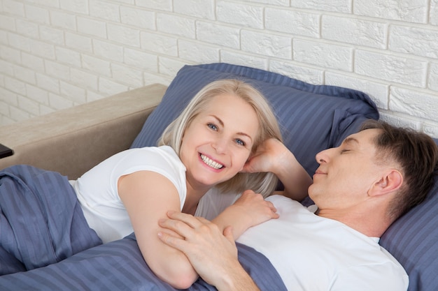 Ouder mooi paar liggend op bed in de slaapkamer.