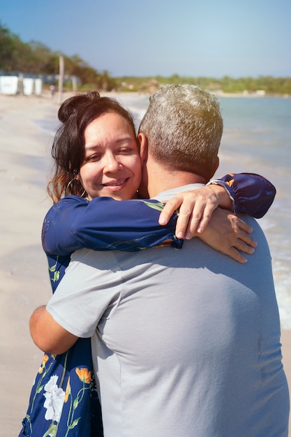 Ouder paar knuffelen en wandelen op het strand