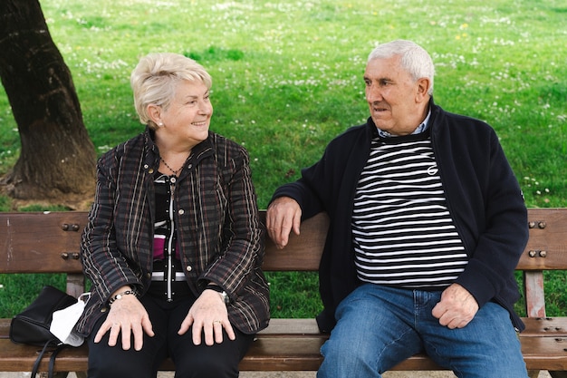 Ouder paar lachen zittend op een bankje Senior man en vrouw genieten van pensioen