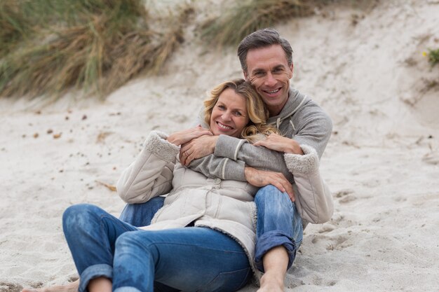 Ouder paar omhelzen elkaar op het strand