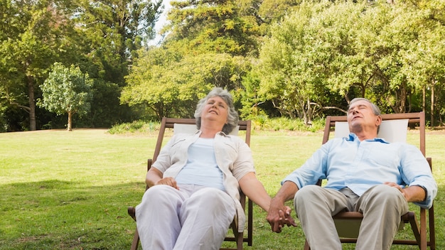 Ouder paar ontspannen op zondag ligstoelen