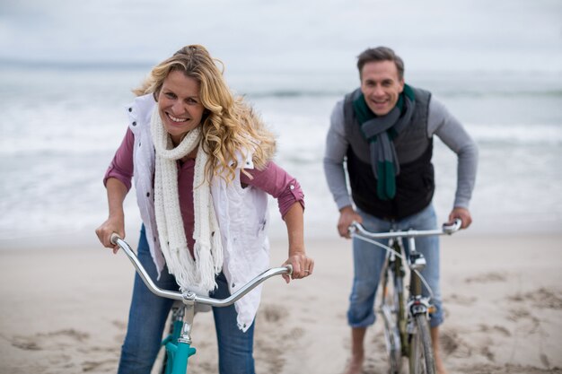 Ouder paar paardrijden fietsen op het strand