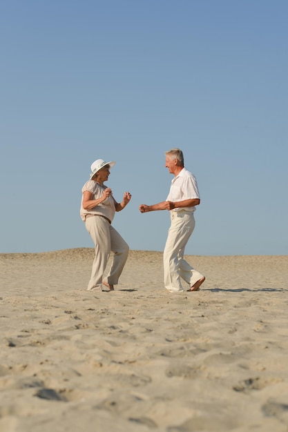 Ouder verliefd stel loopt op blote voeten in het zand