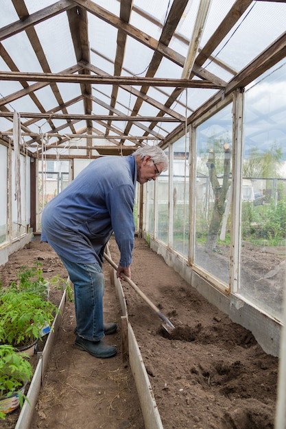 Oudere man aan het werk in de tuin