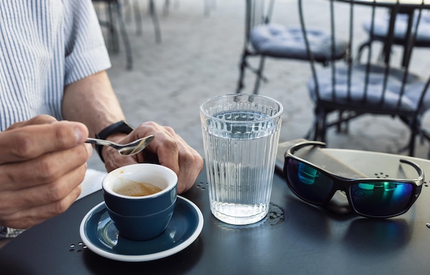 Oudere man die espressokoffie drinkt op een terrasje