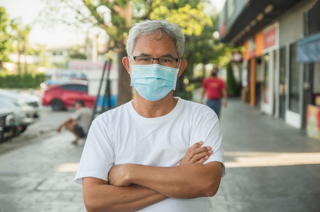 Oudere man draagt gezichtsmasker en beschermt coronavirus covid19 in de openbare stad