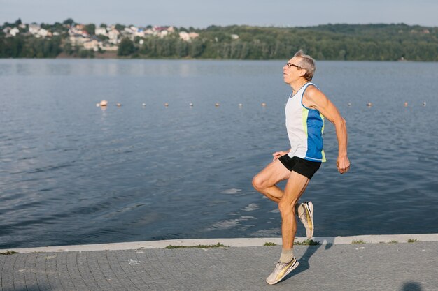 Oudere man houdt zich bezig met hardlopen in de frisse lucht. Hoge kwaliteit foto