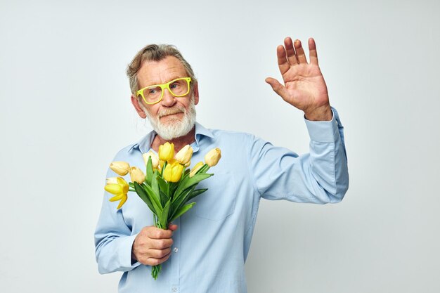 Oudere man in een blauw shirt met een boeket bloemen bijgesneden weergave