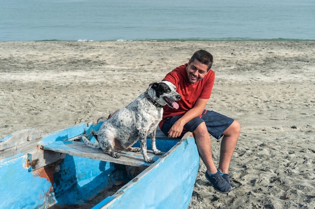 Oudere man met een zwart-witte hond op het strand