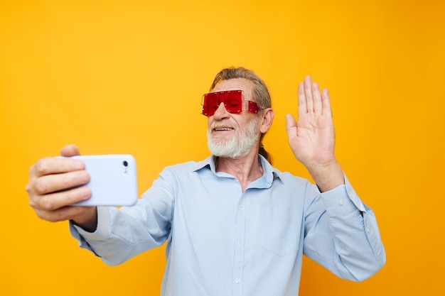 Oudere man mode rode bril telefoon selfie technologie