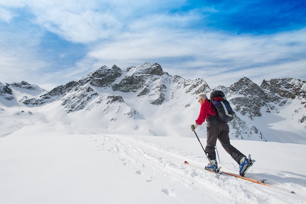 Oudere man sportieve fit ski's bergopwaarts klimmen in de alpen