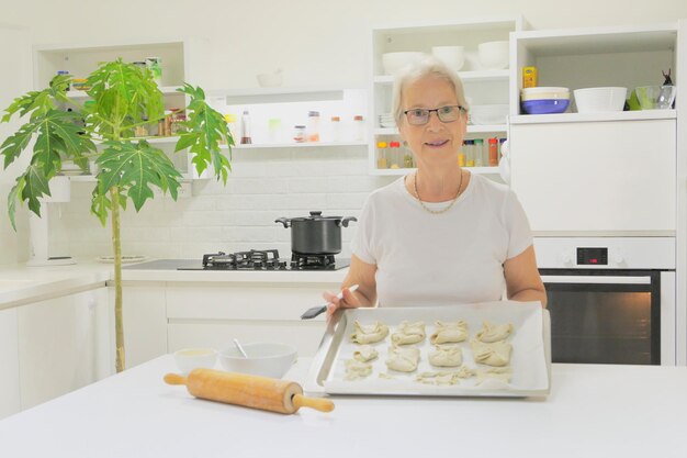 Oudere vrouw die eten bereidt in de keuken