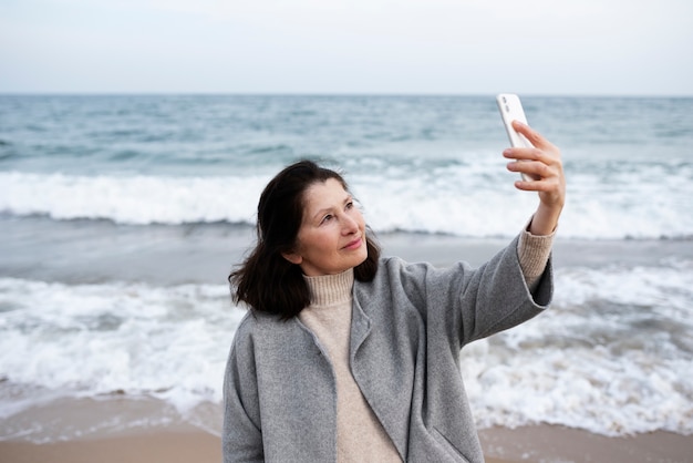 Oudere vrouw die langs de kust loopt