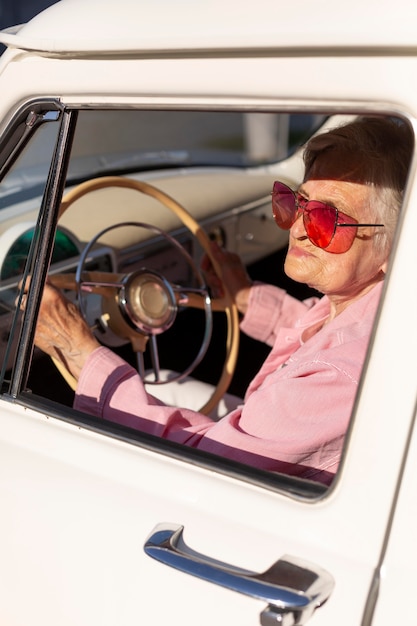 Foto oudere vrouw die met haar auto reist