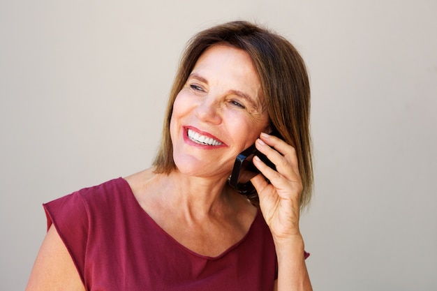 Oudere vrouw die op mobiele telefoon spreekt