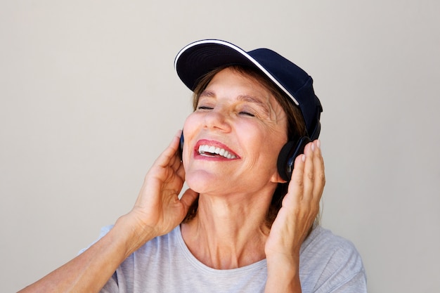 Oudere vrouw die van muziek op hoofdtelefoons geniet