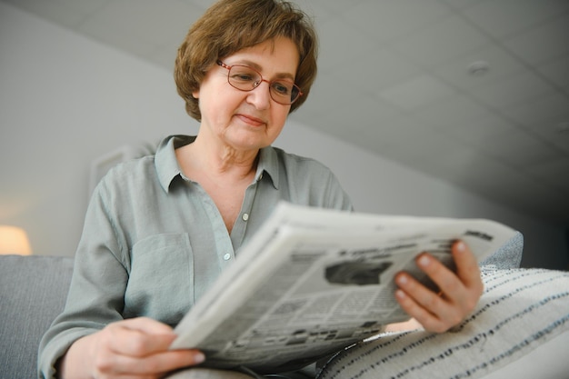 Oudere vrouw elaxing en het lezen van de krant