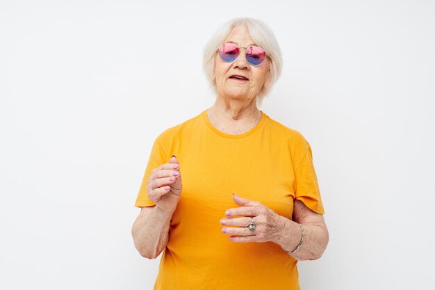 Oudere vrouw in een gele t-shirt poseren close-up emoties