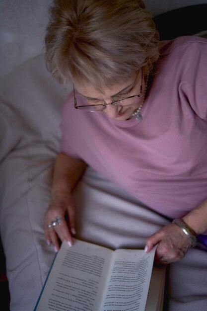 oudere vrouw leest een boek thuis