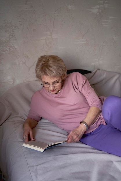 oudere vrouw leest een boek thuis
