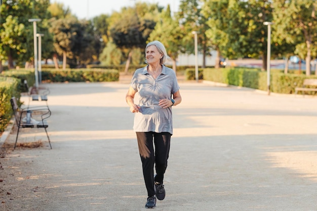 Foto oudere vrouw loopt voor camera in een park