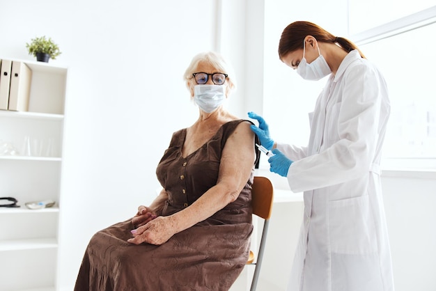 Oudere vrouw met een epidemie van het immunisatieveiligheidsvirus van een arts