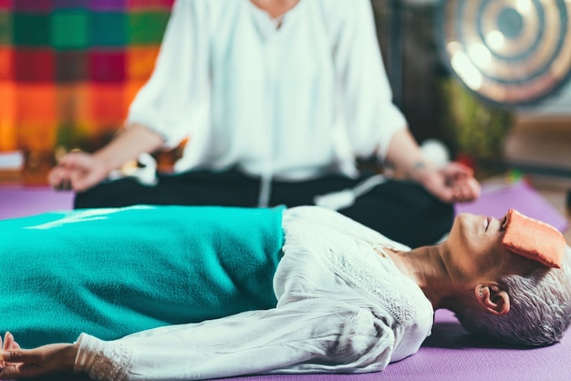 Oudere vrouw op een begeleide meditatie les
