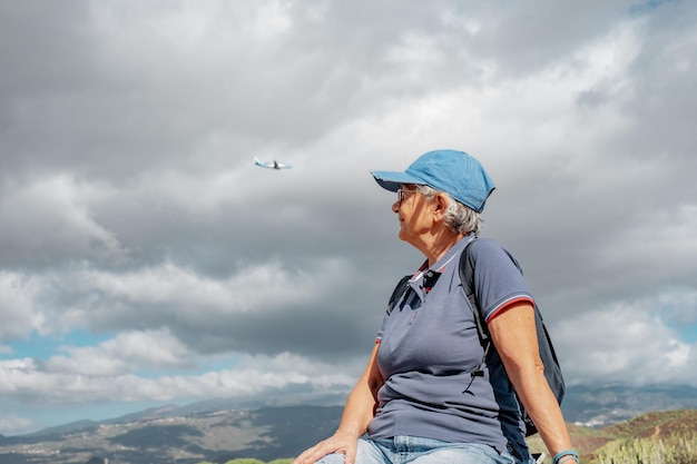 Oudere vrouw op een wandeldag op een openluchtpad op een excursie op het platteland die van avontuur geniet