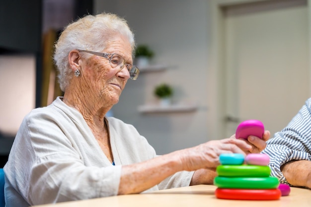 Oudere vrouw speelt behendigheidsspelletjes in een verpleeghuis